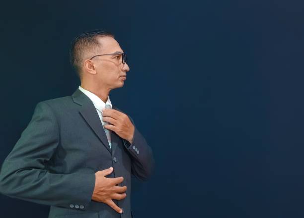 istock Isolated image of businessman is fixing his tie. 1498643503
