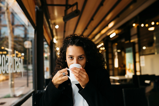 Young woman drinking coffee in a coffeeshop