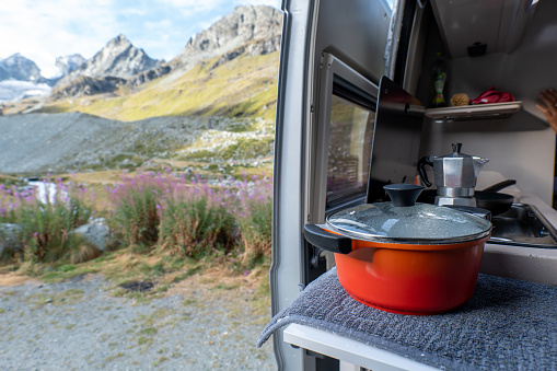 Adventure camping outdoors comfort concept.
traveling with a van, parked beside an alpine lake and glacier