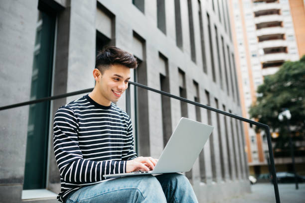 istock Man using a laptop on the street 1498644801