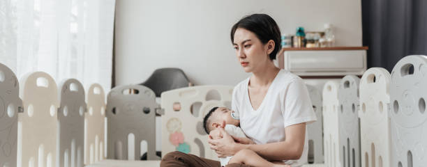 tired asian mother suffering from experiencing postnatal depression. healthcare single mom motherhood stressful. - babybox stockfoto's en -beelden