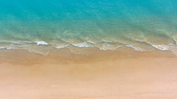 ターコイズブルーの海水ショットの波にビーチを持つ空撮、美しい白い砂の背景の上面図