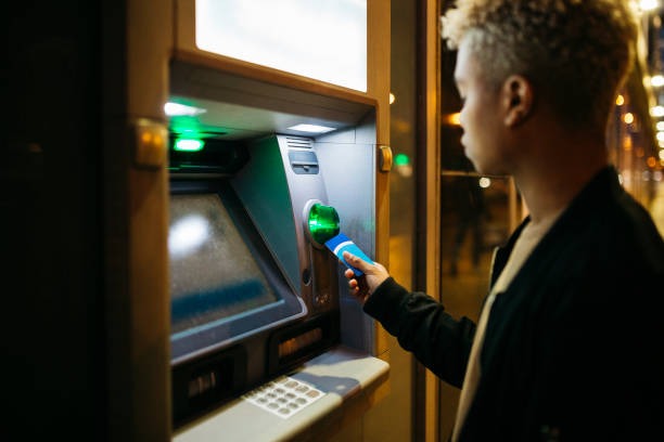 istock Young man withdrawing money at a bank teller 1498647142