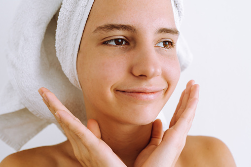 Portrait young woman, teenager girl, with white towel on head, with teenage acne, black dots, dirty skin on face. Acne problem, comedones. Profile. Cosmetology dermatology concept