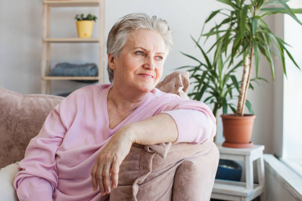 istock Smiling middle aged mature grey haired woman at home 1498649364