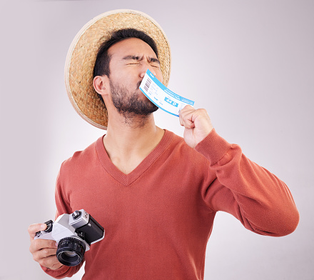 Excited man, ticket and visa with camera, travel and paperwork for holiday adventure and on white background. Smile, travel and happy person kissing boarding pass for vacation, journey and happiness.