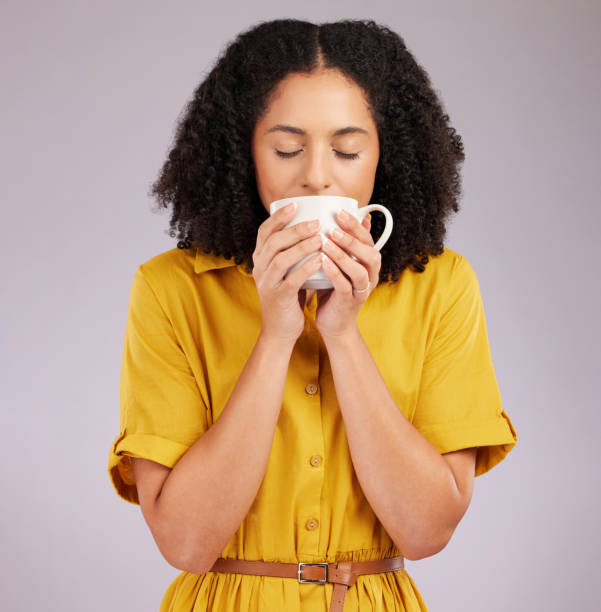 istock Woman, coffee and drinking mug in studio, backdrop and background for warm beverage, latte and smell of espresso. Female model enjoying cup of tea, cappuccino and good mood for break, calm and peace 1498653997