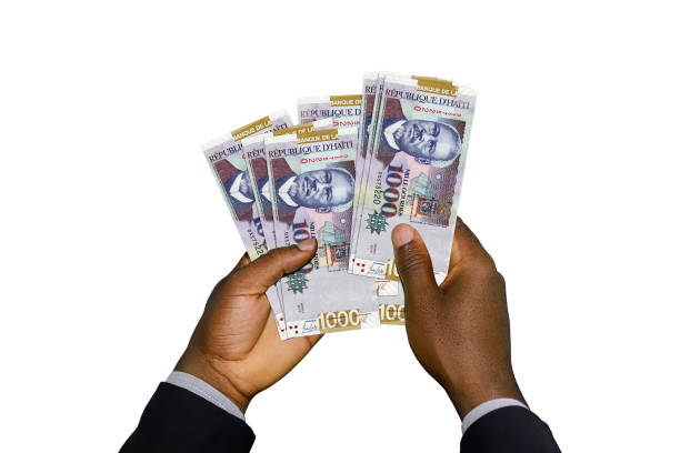 istock Black Hands in suit holding Haitian gourge notes 1498656463