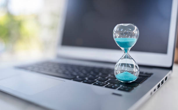 istock Hourglass on laptop computer concept for time management background 1498656524