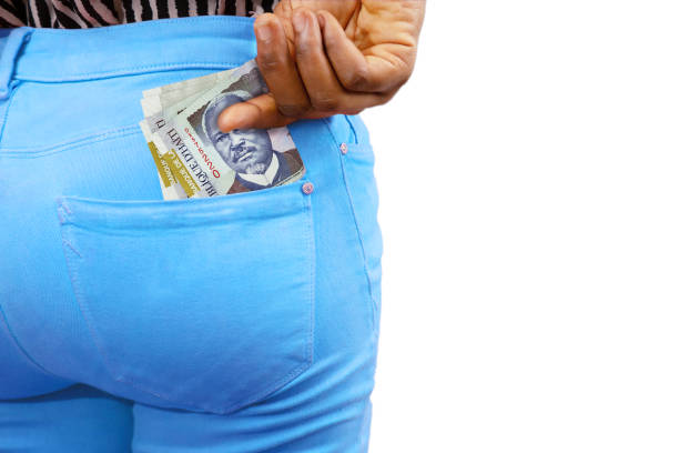 istock Black lady putting few Haitian gourge notes into her back pocket. Removing money from pocket, hold money 1498656625