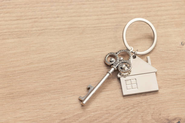 istock Keys to Home: House Key chain Resting on Wooden Table 1498657171