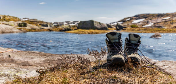 Mountain boots on a lake in the mountains stock photo