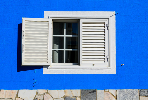 Colorful and bright typical facade in Tavira town with white window