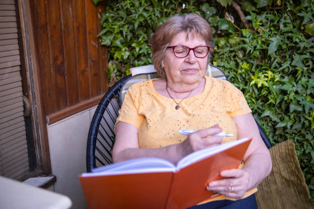istock Senior woman using a note book to write down her health status 1498664351