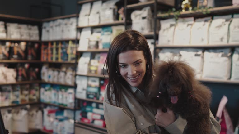 Young woman with poodle in pet shop