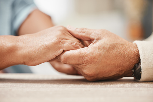 Support, praying or old couple love holding hands together in a Christian home in retirement with hope, belief or faith. Jesus, senior man and woman with peace in prayer to God for spiritual bonding