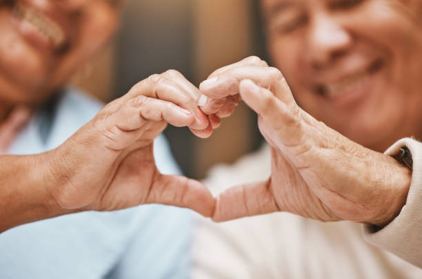 istock Love, heart hands or happy old couple with support, trust or hope in a marriage commitment at home.  Romance, valentines day or senior man smiles with an elderly woman relaxing on anniversary 1498669856