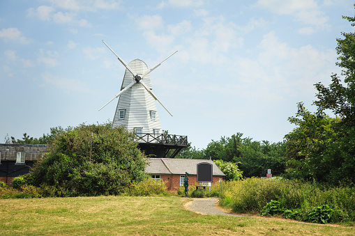 Lytham, United Kingdom - June 18, 2016: Lytham windmill on a sunny day sited at Lytham Green, 2 people can be seen in the distance, Lytham St Annes, Lancashire, UK