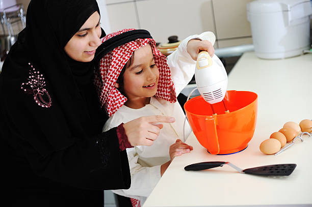 musulmana madre e hijo en la cocina pequeña - single word islam religion text fotografías e imágenes de stock