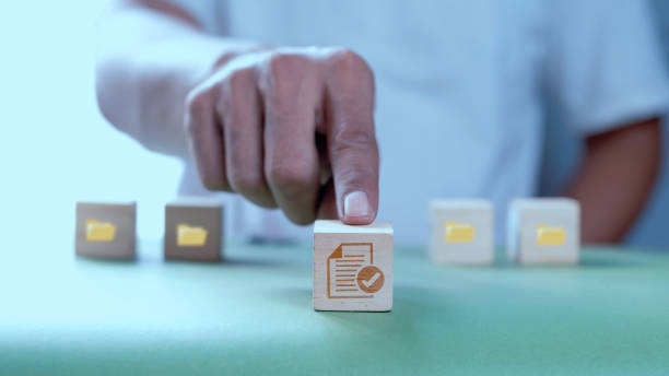 istock Businessman pushing wooden cube with documents icon. 1498676513