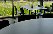 Dining table by the window. retractable automatic blinds. the sensor evaluates the lighting of the building and issues a command to the shutter motors. large windows of office building. blacked out