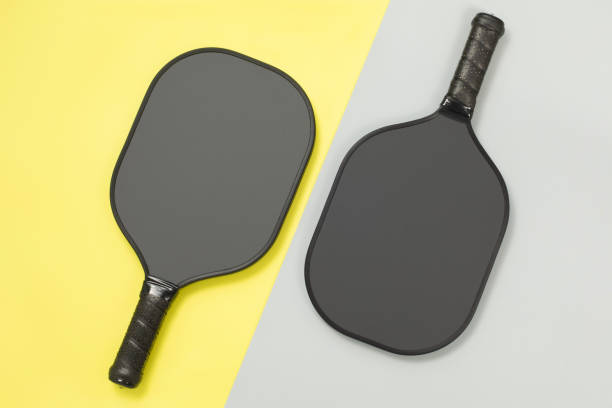 istock Two pickleball paddles on yellow and gray background 1498686097