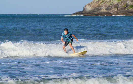 Initial process of learning to surf, with a board and beach suitable for the practice