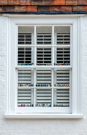 Rye, England - June 13, 2023: Dozens of Minifigure Legos lined up in a window in Rye, East Sussex.