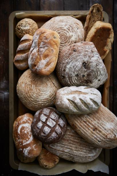 some breads and rolls are piled on a plate in a wooden crate