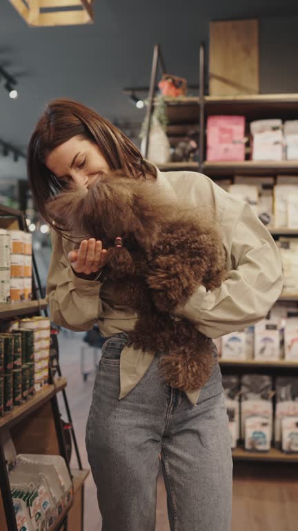 Young woman with poodle in pet shop