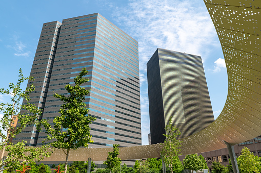 Dallas, Texas, USA. 2 June 2023. Curved sun shade at Pacific Plaza in central Dallas, Texas with city behind.