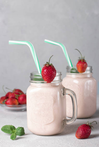 istock Homemade smoothie with strawberries in Mason jars with drinking straws, Vertical format 1498700417