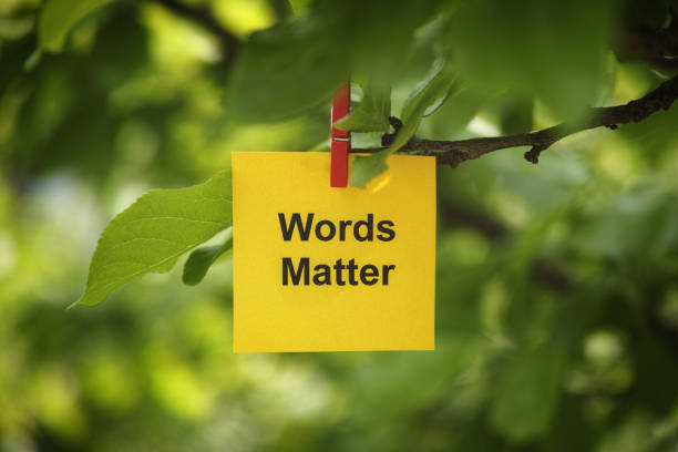 istock A yellow paper note with the phrase Words Matter on it attached to a tree branch with a clothes pin 1498702700