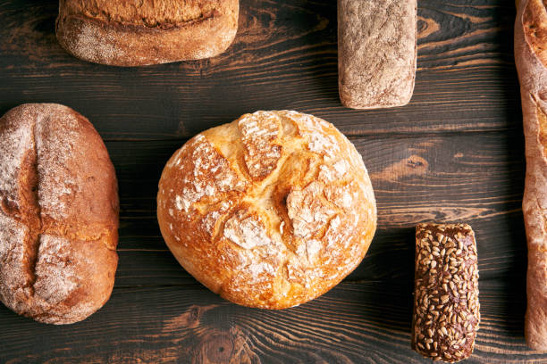 istock Different types of bread loaves on dark wooden background 1498702855