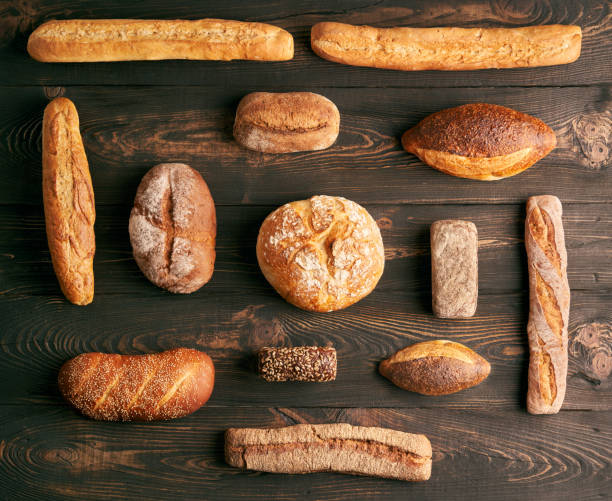 istock Different types of bread loaves on dark wooden background 1498702870