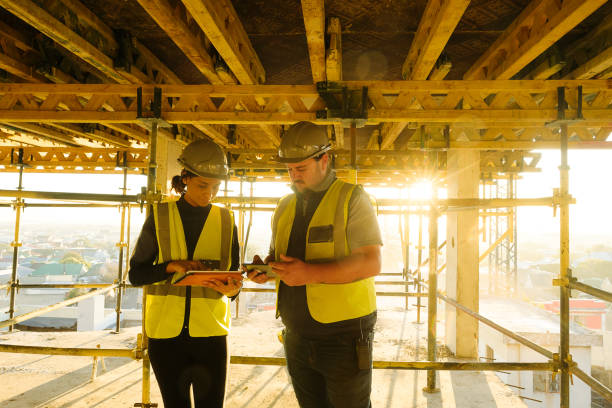 istock Sunrise Female and Male foreman and engineers with PPE on tablets on Construction Site at sunrise 1498703338