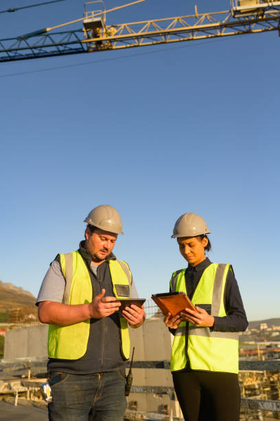 istock Male and female architects with hard hats discussing plans on digital tablets on a construction site oudtoors 1498704679