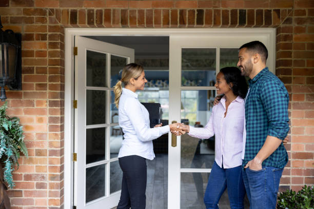 istock Real estate agent greeting a couple with a handshake 1498704719