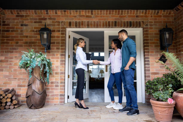 istock Real estate agent greeting a couple with a handshake 1498704730
