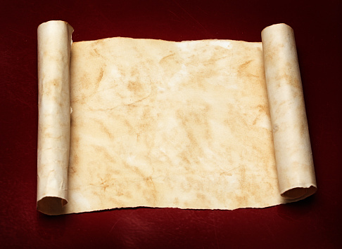 Brown-stained scroll with copy space, on a dark red background.