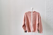 A woolen sweater hanging on a hanger on a white background. Warm clothes sale.