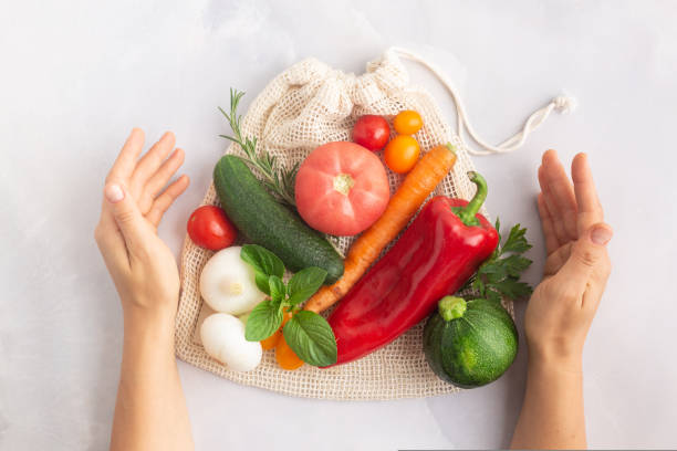 Vegetables above reusable mesh cotton bag, plastic free zero waste concept stock photo