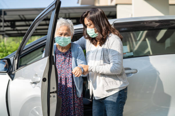 Caregiver help and support asian elderly woman sitting on wheelchair prepare get to her car to travel in holiday. Caregiver help and support asian elderly woman sitting on wheelchair prepare get to her car to travel in holiday. senior adult car nurse physical impairment stock pictures, royalty-free photos & images