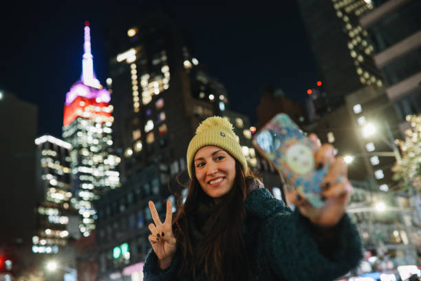 New Yorker woman sending a selfie via messaging app stock photo