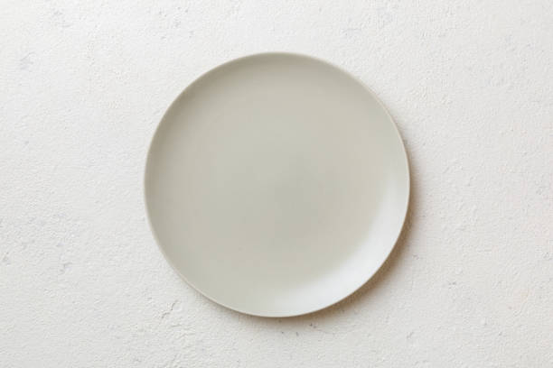istock Top view of empty light plate on cement background. Empty space for your design 1498713725