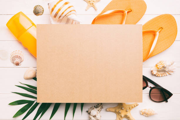 istock Summer time concept with blank greeting card and blank craft paper on colored background. Seashells from ocean shore in the shape of frame separated with space for text top view 1498713751