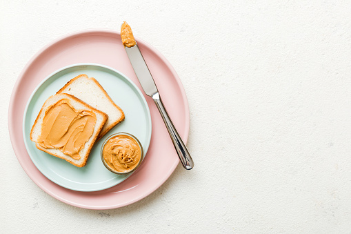 Peanut butter sandwiches or toasts on light table background.Breakfast. Vegetarian food. American cuisine top view vith copy space.