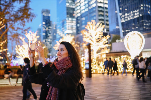 New Yorker woman taking photos with a smartphone stock photo