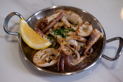 Grilled squid with vegetable and lemon served on plate
