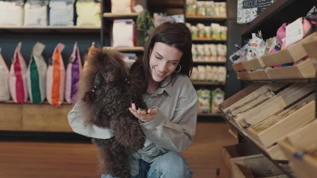 Young woman with poodle in pet shop